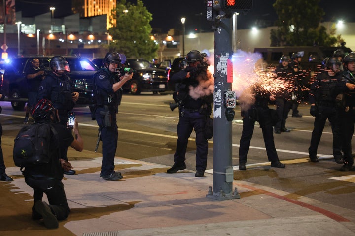 An LAPD officer fires a non-lethal munition while facing protesters during a "National Shutdown" protest against US Immigration and Customs Enforcement in Los Angeles on January 30, 2026. (Photo by Patrick T. Fallon / AFP via Getty Images)