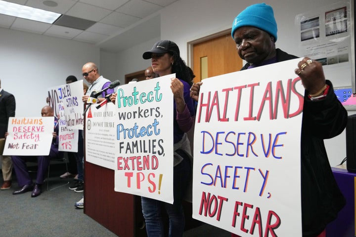 People hold signs during a Jan. 28, 2026 rally in Fort Lauderdale, Fla., in support of the extension of Temporary Protected Status for Haitian immigrants before it expires on February 3. 