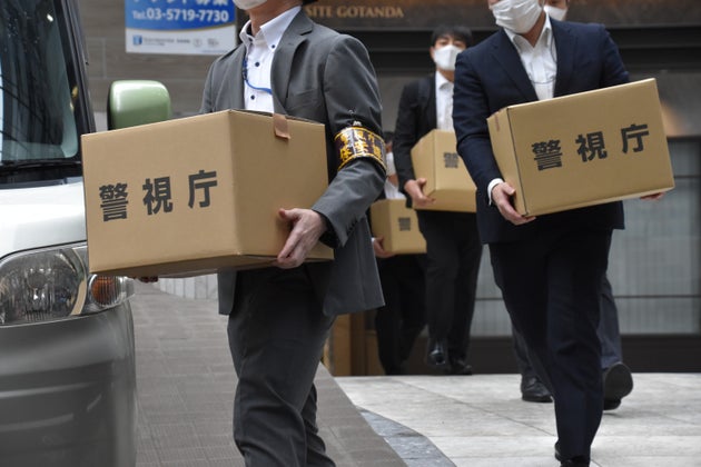 退職代行サービスの運営会社が入るビルから押収物を運び出す警視庁の捜査員ら＝2025年10月22日、東京都品川区