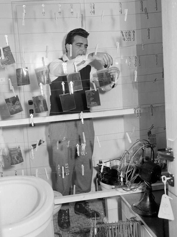 Rome darkroom staffer Carlo Pelliccia dries negatives in a bathroom where film for five Associated Press photographers was being processed during the 1956 Winter Olympics.