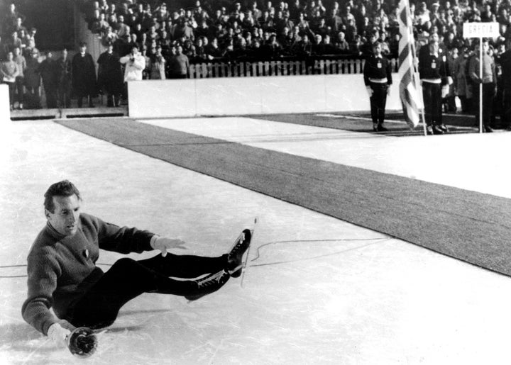 In front of 13,000 people and 1,200 competitors, Italian skater Guido Caroli falls while carrying the Olympic torch during the opening ceremony.