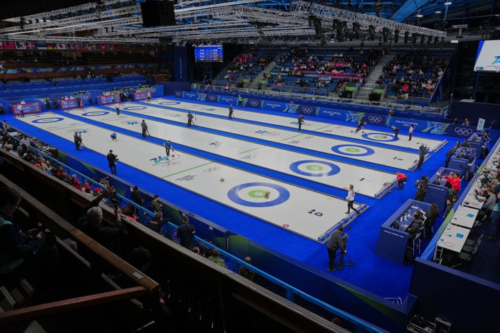 Athletes play mixed doubles curling match at the 2026 Winter Olympics, in Cortina d'Ampezzo, Italy, Wednesday, Feb. 4, 2026. (AP Photo/Misper Apawu)