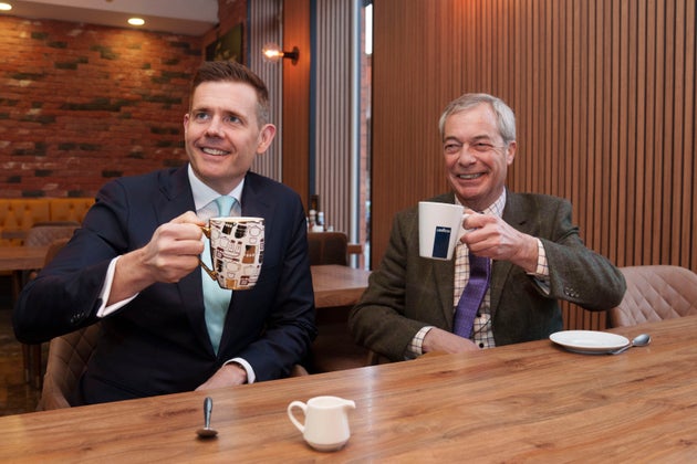 Reform leader Nigel Farage, right, sits in a cafe with prospective candidate Matt Goodwin during a campaign visit to Gorton and Denton in Manchester, England, Friday, Jan. 30, 2026. (AP Photo/Jon Super)