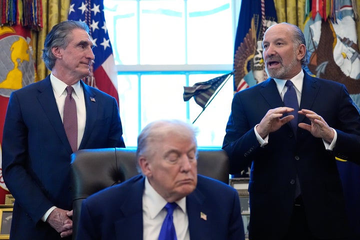 Commerce Secretary Howard Lutnick, right, speaks in the Oval Office of the White House during a event with President Donald Trump, Monday, Feb. 2, 2026, in Washington, as Interior Secretary Doug Burgum listens. (AP Photo/Alex Brandon)