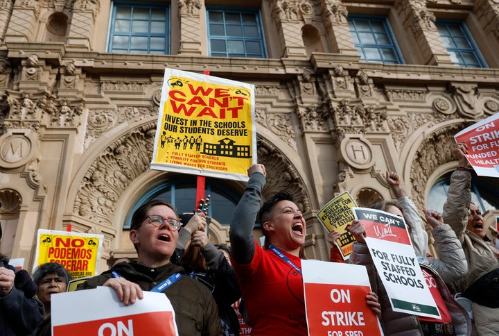 Teachers hold signs on the steps of Mission High School in San Francisco on the first day of a citywide teachers' strike on Feb. 09, 2026.