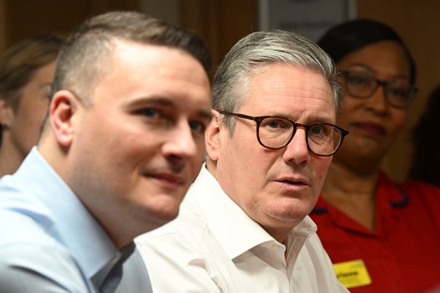 Britain's Prime Minister Keir Starmer, center, accompanied by Health Secretary Wes Streeting, left, visit a healthcare provider to deliver remarks on reducing NHS wait times, in Surrey, England, Monday, Jan. 6, 2025.