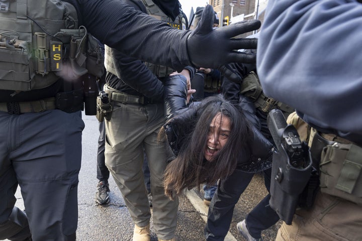 Federal agents arrest a woman after smashing the windows of her car during an immigration enforcement operation after she allegedly blocked a street in Minneapolis.
