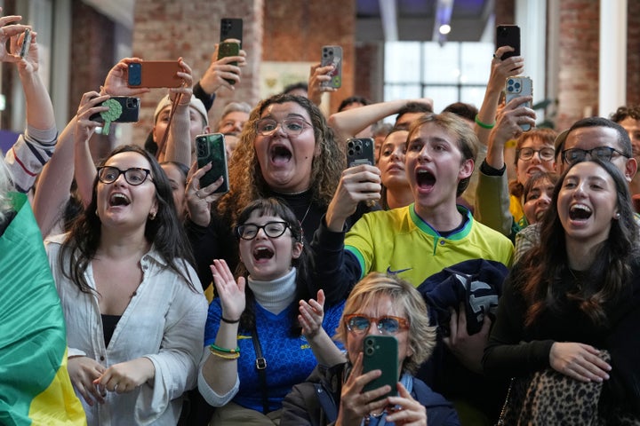 Supporters of Brazil's Lucas Pinheiro Braathen react at the Brazil House as he begins his second run in the men's giant slalom at the 2026 Winter Olympics in Milan, Italy, Saturday, Feb. 14, 2026. (AP Photo/Antonio Calanni)