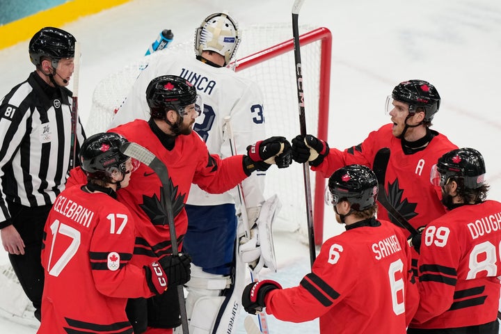Canadian Tom Wilson (center left) celebrates after scoring a goal against French goalkeeper Julian Junca (top center) on Sunday.