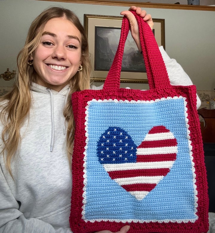 Speedskater Greta Myers shows off a crocheted bag she completed while competing in the Olympic trials.