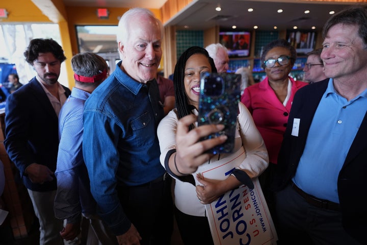 Sen. John Cornyn, R-Texas, left, poses for photos and visits with supporters during a campaign stop in Austin, Texas, Tuesday, Feb. 17, 2026.