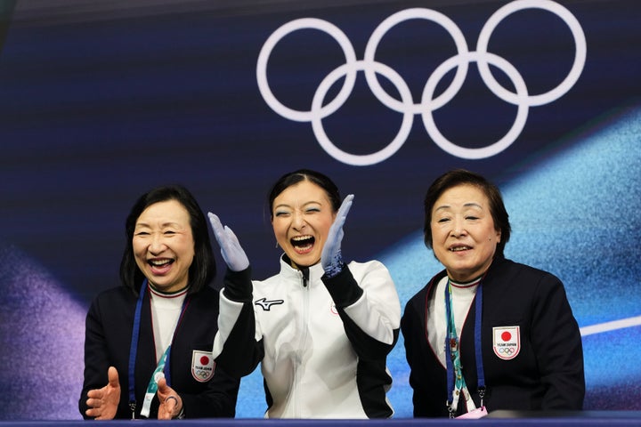 Japan's Kaori Sakamoto (center) reacts to her score after competing in the women's figure skating short program.