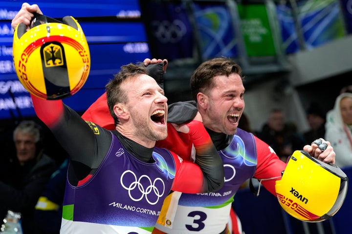 German bronze medalists Tobias Wendl (left) and Tobias Arlt celebrate the finish during a men's doubles luge race.