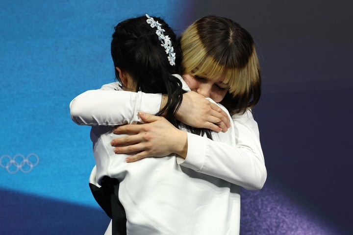 Gold medalist American figure skater Alysa Liu celebrates with Japanese bronze medalist Ami Nakai.