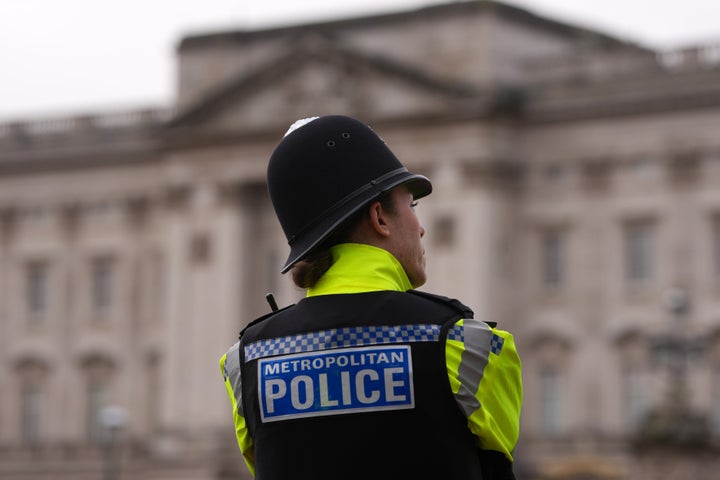A Metropolitan police officer stands in front of Buckingham Palace in London on Friday after Andrew Mountbatten-Windsor was arrested and held for hours by British police on suspicion of misconduct in public office related to his links to Jeffrey Epstein.