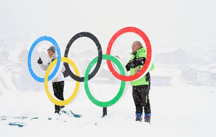 Fans pose for a photo with the Olympic rings after heavy snowfall in Livigno on Thursday.
