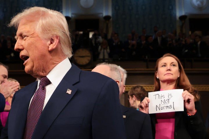 Rep. Melanie Stansbury (D-N.M.) holds as a sign reading "This is not normal" as Trump enters the House chamber to deliver an address to a joint session of Congress on March 4, 2025. 