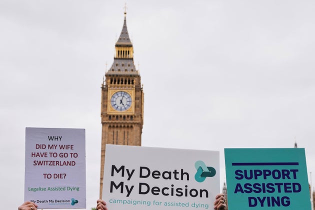 Banners are held by pro-assisted dying campaigners as they gather outside Parliament last year.