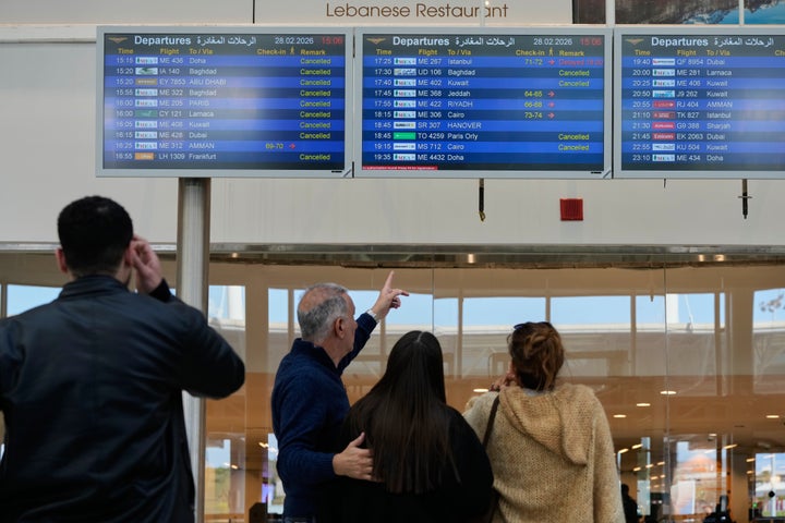 Travelers check their departure times as many flights are canceled at Beirut Rafik Hariri International Airport in Beirut, Lebanon, on Saturday, February 28, 2026, as many airlines also cancel flights due to conflicts involving the United States, Israel and Iran. (AP Photo/Hassan Ammar)