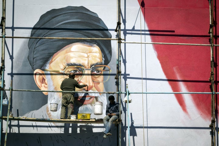An Iranian worker puts the final touches to a mural of Iran's supreme leader, Ayatollah Ali Khamenei, at Enghelab (Revolution) square on February 27, 2012 in Tehran, Iran. (Photo by Majid Saeedi/Getty Images)