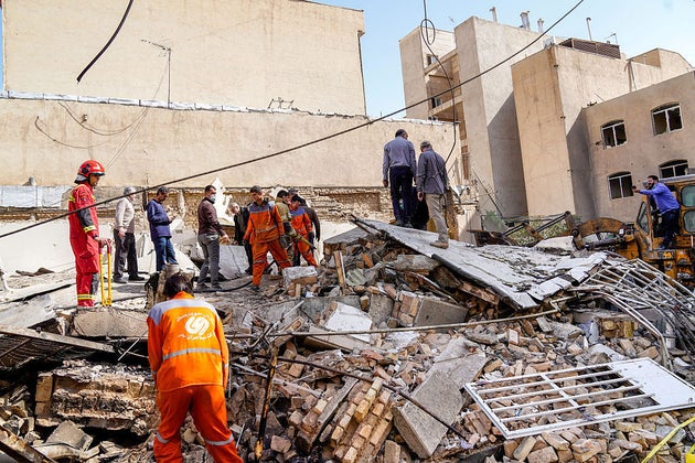 Rescuers search through the rubble of a collapsed building at the site of a strike on a neighbourhood in Tehran.