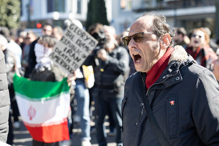A protester chants slogans during a rally against U.S. and Israeli strikes on Iran, outside the U.S. embassy in Athens, Greece, Sunday, Mar. 1, 2026. (AP Photo/Yorgos Karahalis)