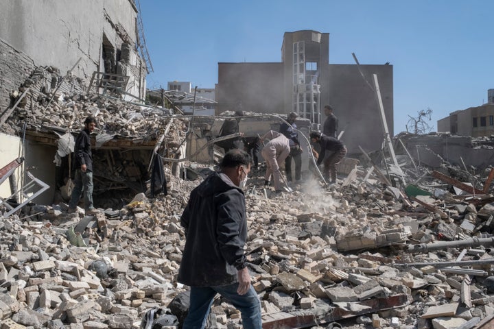 A group of unidentified men work among the ruins of a police station that was struck on Monday during U.S.-Israeli attacks in Tehran, Iran.