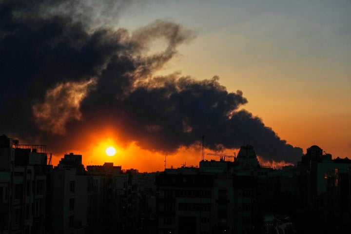 The sun sets behind a plume of smoke rising after a U.S.–Israeli military strike in Tehran, Iran, on March 3, 2026.
