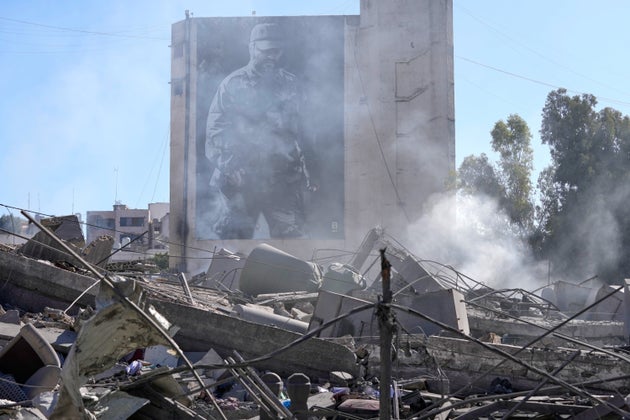 A giant poster shows the late Hezbollah military commander Imad Mughniyeh, behind a destroyed building that was hit by an Israeli airstrike in Nabatiyeh town, south Lebanon.