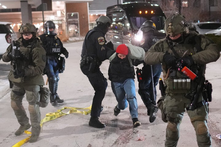 Law enforcement officers detain a demonstrator during a protest outside SpringHill Suites and Residence Inn by Marriott hotels on Jan. 26, 2026, in Maple Grove, Minn.