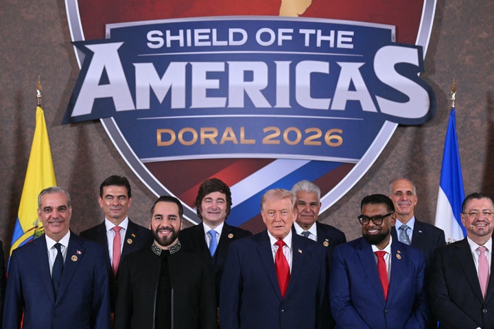 President Donald Trump stands with (L/R) Trinidad and Tobago Prime Minister Kamla Persad-Bissessar, Dominican Republic President Luis Abinader, Bolivian President Rodrigo Paz Pereira, El Salvador President Nayib Bukele, Argentina President Javier Milei and Panama President Jose Raul Mulino Irfan Ali, President of Guyana, Nasry "Tito" Asfura, President of Honduras and Rodrigo Chaves Robles, President of Costa Rica, during a group photograph at the start of the "Shield of the Americas" Summit at Trump National Doral in Miami, Florida, March 7, 2026. (Photo by SAUL LOEB / AFP via Getty Images)