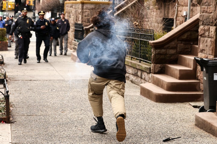 A man carrying a homemade explosive device runs towards police before throwing it at them during the anti-Islam protest outside of the residence of New York City Mayor Zohran Mamdani.