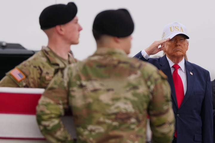 President Donald Trump salutes as an Army transport team moves the flag-draped transfer case containing the remains of U.S. Army Reserve Sergeant Declan Coady, 20, of West Des Moines, Iowa, who was killed in a drone strike on a command center in Kuwait. (AP Photo/Julia Demaree Nikhinson)