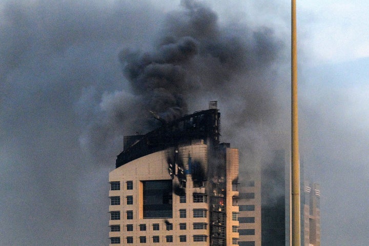 TOPSHOT - Smoke rises from a high-rise building following a drone attack in Kuwait City on March 8, 2026. The United States and Israel launched strikes against Iran on February 28, sparking swift retaliation by the Islamic republic which responded with missile attacks across the region. The war has dragged in global powers, upended the world's energy and transport sectors, and brought chaos to even usually peaceful areas of the volatile region. (Photo by AFP via Getty Images) / Kuwait OUT