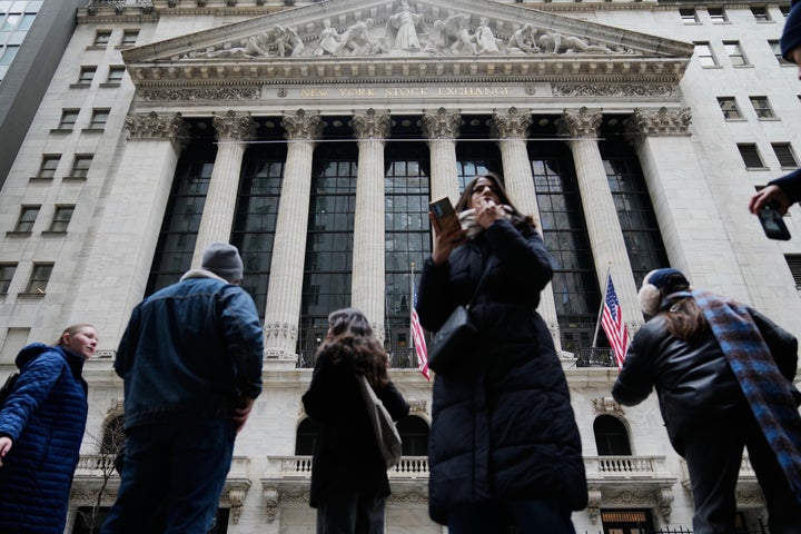 Pedestrians mill about outside the New York Stock Exchange in New York, Friday, March 6, 2026. (AP Photo/Seth Wenig)