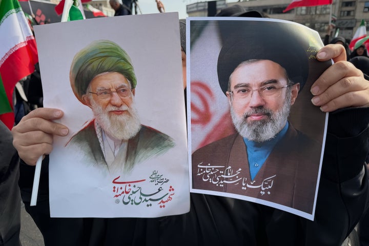 A woman holds posters of Ayatollah Mojtaba Khamenei, right, the successor to his late father, Ayatollah Ali Khamenei, left, as supreme leader, during a rally supporting him in Tehran, Iran, on March 9, 2026.