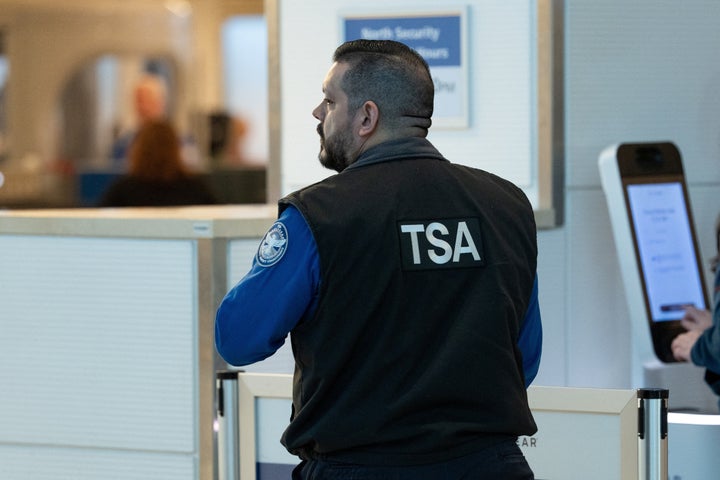 A Transportation Security Administration (TSA) agent works at a security checkpoint at Ronald Reagan National Airport in Arlington, Virginia, on Monday.