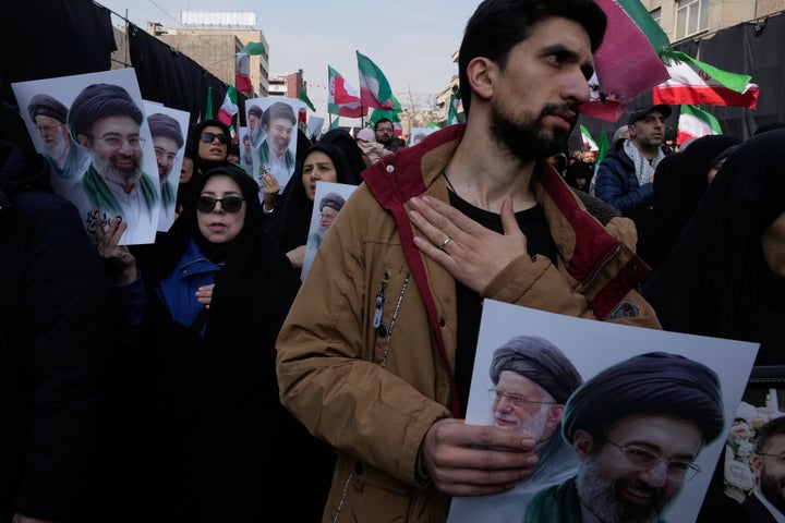 Mourners beat their chests as they hold posters depicting Ayatollah Mojtaba Khamenei, right in the posters, the successor to his late father Ayatollah Ali Khamenei, left in the posters, as supreme leader, during the funeral procession for senior Iranian military officials and civilians killed during the U.S.-Israel campaign in Tehran, Iran, Wednesday, March 11, 2026. (AP Photo/Vahid Salemi)