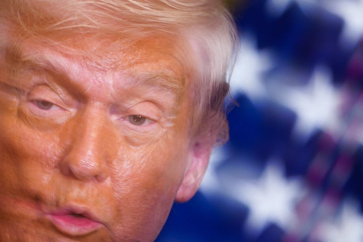 In this image taken with a slow shutter speed, President Donald Trump speaks Thursday during a women's history month event in the East Room of the White House.