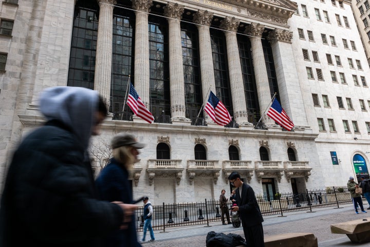 NEW YORK, NEW YORK - MARCH 13: People walk outside of the New York Stock Exchange (NYSE) in lower Manhattan on March 13, 2026 in New York City. The Dow was up over 100 points in morning trading as events in Iran continue to upend global markets. (Photo by Spencer Platt/Getty Images)