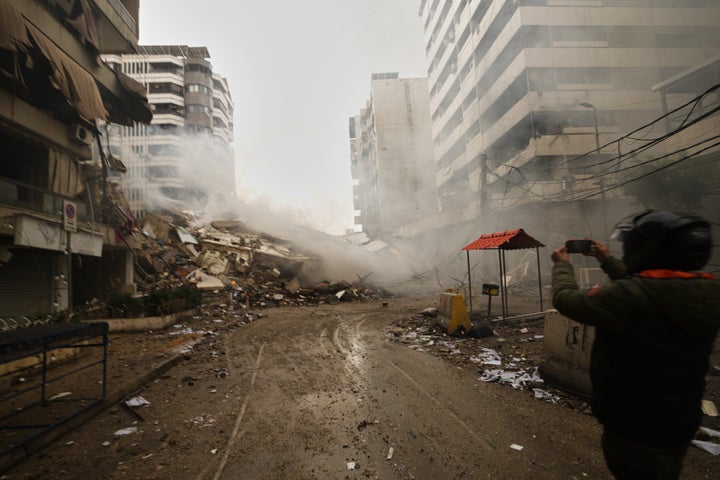 A man photographs the rubble of buildings destroyed in an Israeli airstrike in Dahiyeh, Beirut's southern suburbs, Lebanon, Sunday, March 15, 2026. (AP Photo/Hassan Ammar)