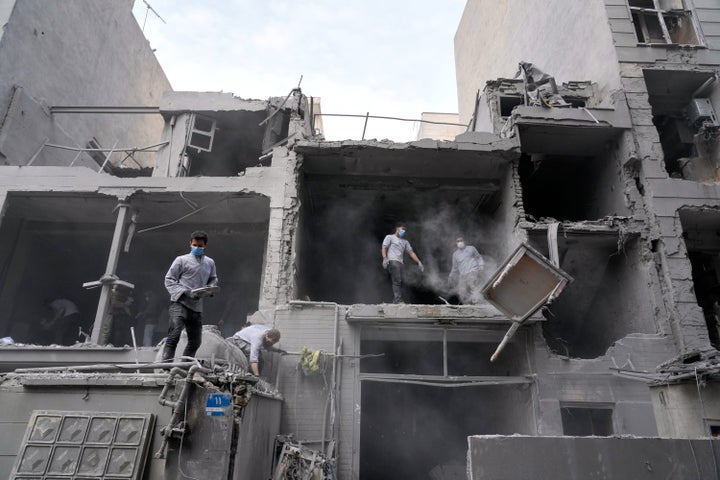 Volunteers clean debris from a residential building damaged when a nearby police station was hit Friday in a U.S.-Israeli strike in Tehran, Iran, Sunday, March 15, 2026. (AP Photo/Vahid Salemi)
