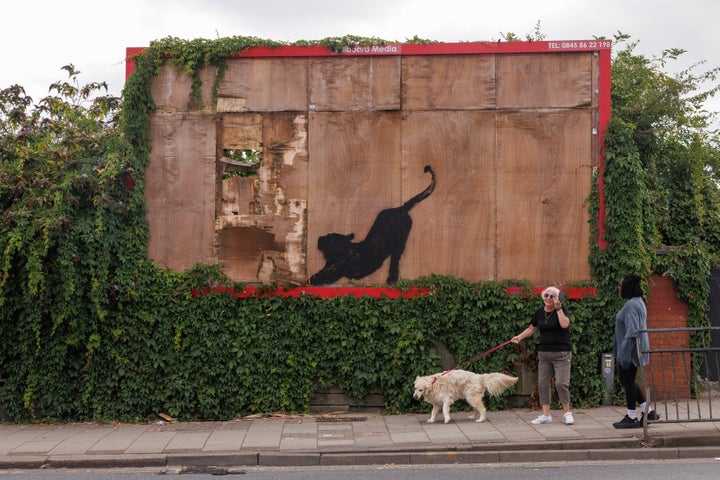 LONDON, ENGLAND - AUGUST 10: An image of a large cat stretching, believed to be by street artist Banksy has appeared on a bare wooden advertising hoarding on Edgware Road in Cricklewood, on August 10, 2024 in London, England. (Photo by Dan Kitwood/Getty Images)
