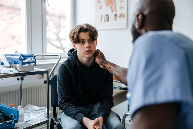 Doctor checking teen's neck