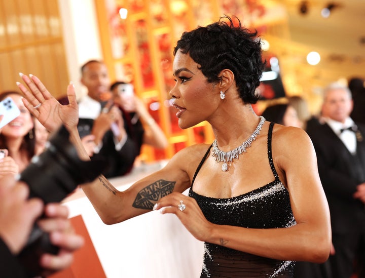 Taylor talks to someone in the crowd on the Oscars red carpet.