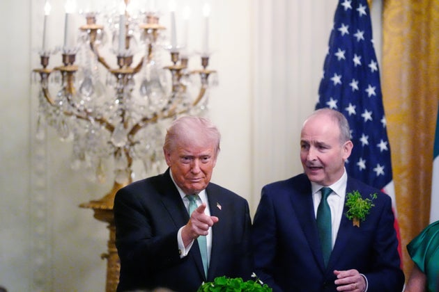 President Donald Trump and Irish Prime Minister Micheál Martin stand over a bowl of shamrocks during an event in the East Room of the White House, on St. Patrick's Day, Tuesday, March 17, 2026, in Washington.