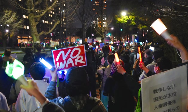 3月19日夜、議員会館周辺で「NO WAR」のプラカードやペンライトを掲げて声を上げる人々