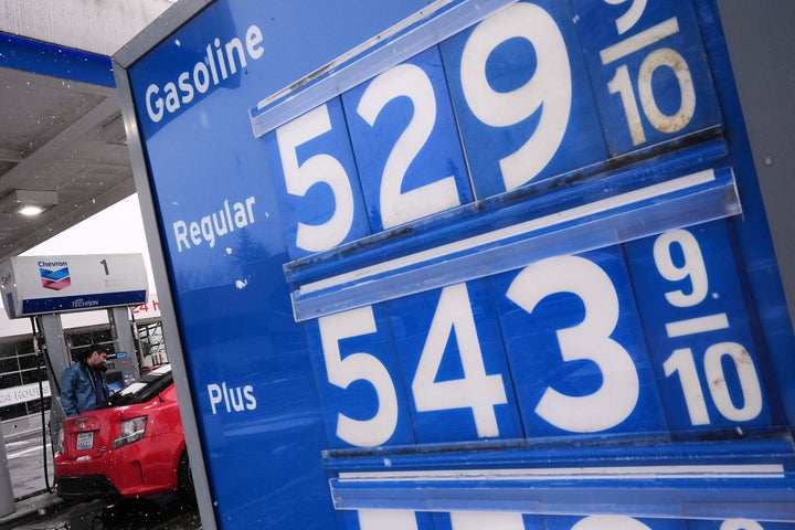 Gas prices are displayed at a Chevron gas station as a customer fuels up in Bellevue, Washington on March 13.