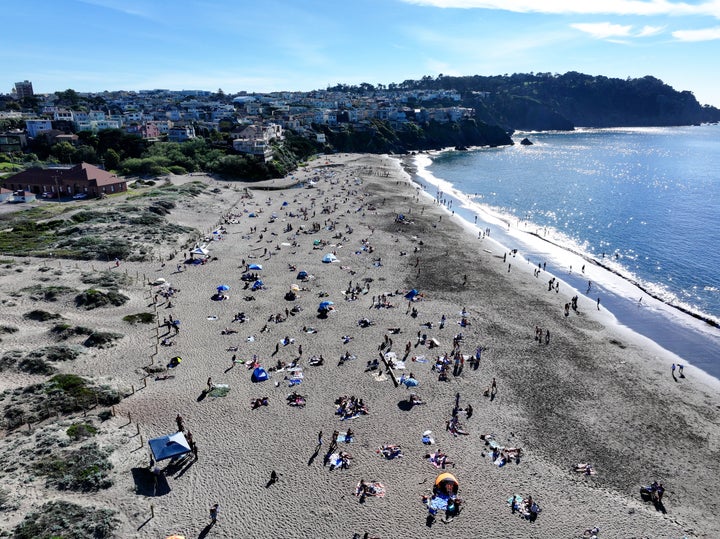 People flock Baker Beach near the Golden Gate Bridge as heat advisory issued in San Francisco on March 16, 2026.
