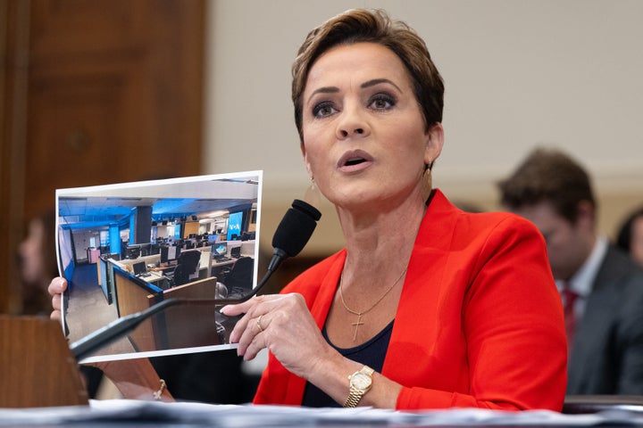 U.S. Agency For Global Media official Kari Lake holds up a photo of the Voice of America newsroom while testifying at a House Foreign Affairs Committee hearing on the future of USAGM, in Washington, D.C., on June 25, 2025.
